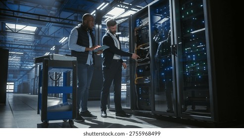 Technicians inspect and maintain server racks in a modern data center, using a tablet to monitor equipment, check connections, operation of network hardware, mainframe, server racks.