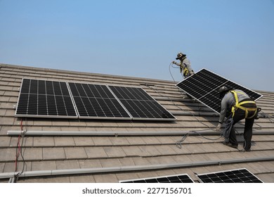 technicians are installing solar panels on the roof to use solar energy to power the building. - Shutterstock ID 2277156701