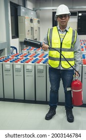 Technicians prepare fire extinguishers for safety in the electrical room.