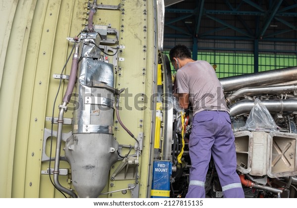 Technicians repair an aircraft gas turbine\
engine in the hangar.Close up of mechanics inspect an jet machine\
and system in aerospace\
industry.