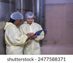 Technicians staff woman and man caucasian two person smiling talk and inspect check quality control working job in wine vats barrels on modern technology winemaking factory industry plant warehouse.