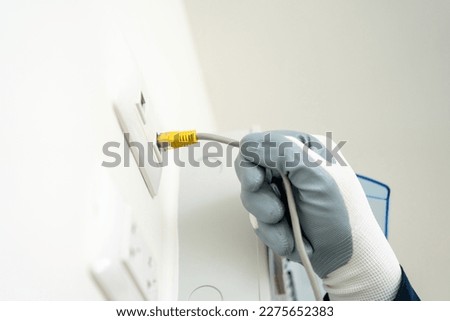 Technicians in uniform installing  network cable and using tablet  for maintenance. Electrician man checking home internet network. Home service concept.