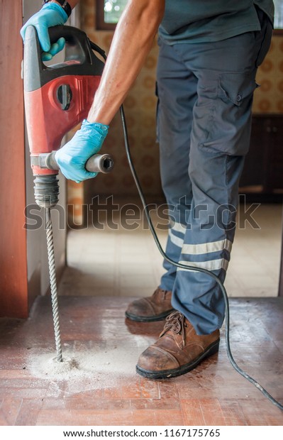 Technicians are using electric\
drill to penetrate the wood to compress chemical termite.Parquet\
drilling