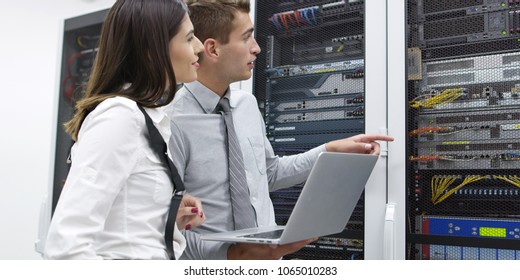 Techniker, die Laptop verwenden, während sie Server im Serverraum analysieren