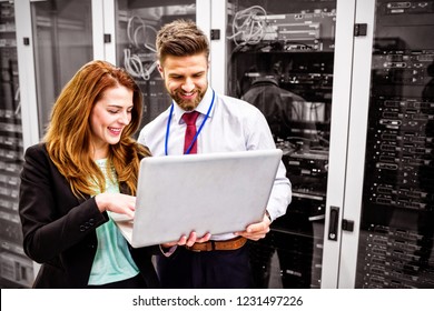 Technicians using laptop while analyzing server in server room - Powered by Shutterstock
