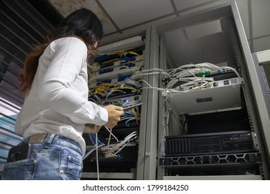 Technicians using laptop while analyzing server in server room