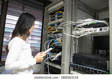 Technicians using laptop while analyzing server in server room