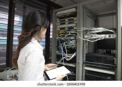 Technicians using laptop while analyzing server in server room