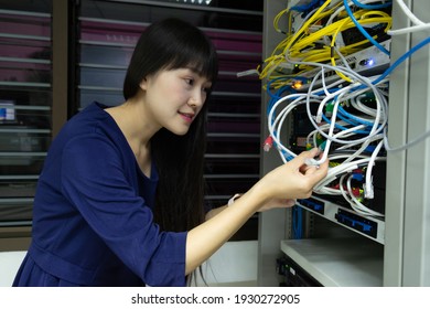 Technicians using laptop while analyzing server in server room.