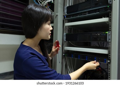 Technicians using laptop while analyzing server in server room.