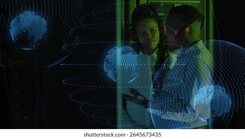 IT technicians wearing ear muffs monitoring server racks on tablet in server room, with data globe. Technology, cybersecurity, networking, digital, innovation, futurism, collaboration