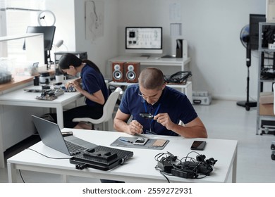 Technicians Working in Electronics Repair Workshop
