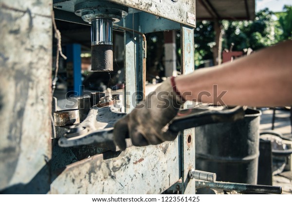 Technicians\
working with hydraulic press. Car\
repair.
