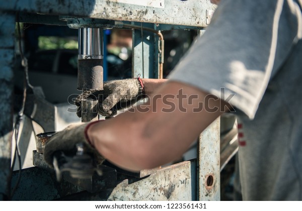 Technicians\
working with hydraulic press. Car\
repair.