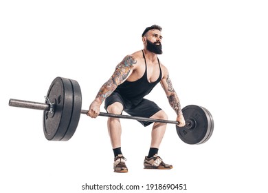 The technique of doing an exercise of deadlift with a barbell of a muscular strong tattooed bearded sports men on a white studio background. Isolate.