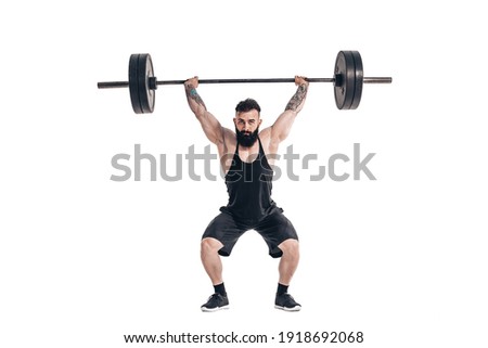 The technique of doing an exercise of deadlift with a barbell of a muscular strong tattooed bearded sports men on a white studio background. Isolate.