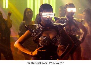 Techno Dancer In Night Club Dancing To The Beat Of Music From DJ . EDM New Year Night Party And Nightlife Concept .