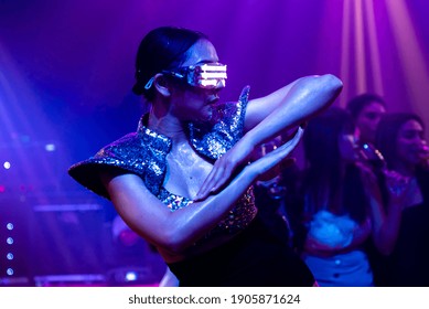 Techno Dancer In Night Club Dancing To The Beat Of Music From DJ . EDM New Year Night Party And Nightlife Concept .