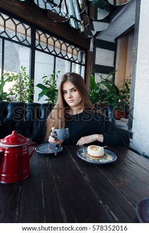 technologies, emotions, lifestyle, people, teens concept -Young happy female reading on her mobile phone while sitting in modern coffee shop interior, gorgeous hipster girl with beautiful smile