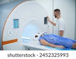 Technologist positioning outpatient for magnetic resonance imaging of brain