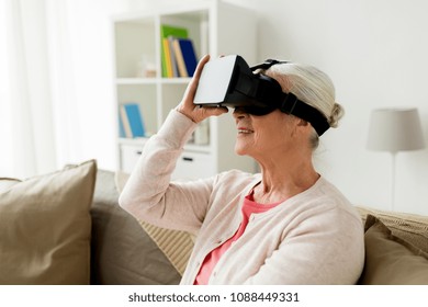 technology, augmented reality, entertainment and people concept - senior woman with virtual headset or 3d glasses playing videogame at home - Powered by Shutterstock