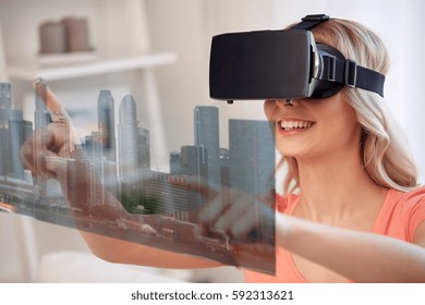 technology, augmented reality, entertainment and people concept - happy young woman in virtual headset or 3d glasses and headphones playing game at home with city skyscrapers on screen projection