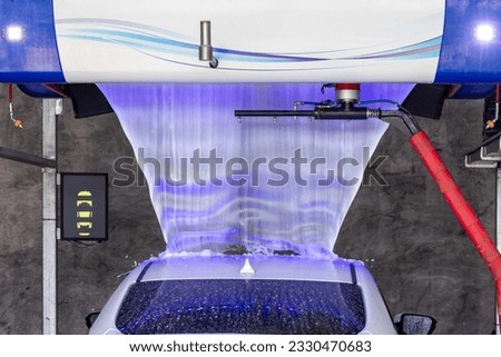 Technology, Automatic car wash machine in action. Car going through an automated wash. High-pressure water spray in the wash machine. Dotted with soap suds. Tunnel Wash Automatic Car. 