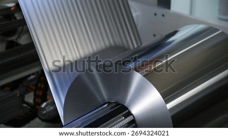 Technology of automatic label printing machine with the digital control panel is printing on continuous plastic film for wrapping on food product packaging in the printing factory. 