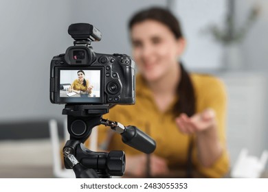 Technology blogger explaining something while recording video at home, focus on camera