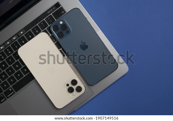 Technology blue work space a macbook\
pro and two iPhone 12 pro: Rome, Italy, february 01,\
2021