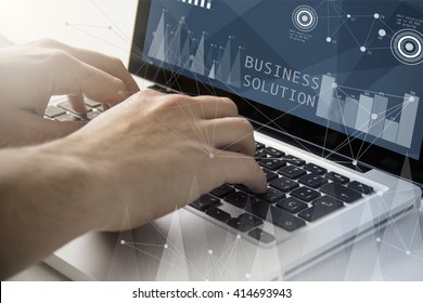 Technology And Business Concept: Man Using A Laptop With Business Solution Software On The Screen. All Screen Graphics Are Made Up.