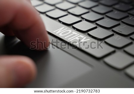 Technology and business concept. On the laptop keyboard of a person's hand, on the space bar there is an inscription - NOTIFY