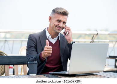 Technology as business necessity. Businessman show thumbs up. Man use mobile and computer technology. New technology. Modern life. Business communication. Technology approved by professionals. - Shutterstock ID 1616599204