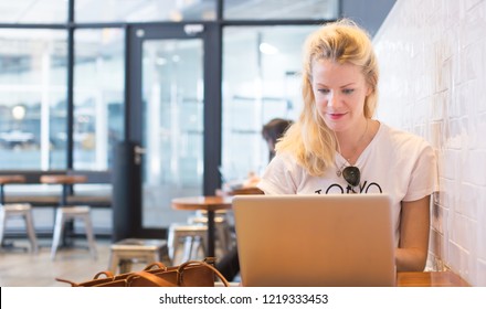 Technology Businesswoman Working on Laptop in Cafe. Young Tech Professional Online Remotely through Computer. Internet Small Business Blogger Manager Entrepreneur. MBA Phd Student Researcher Studying