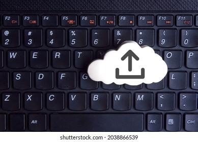 Technology, cloud computing concept. White cloud with upload icon on keyboard
