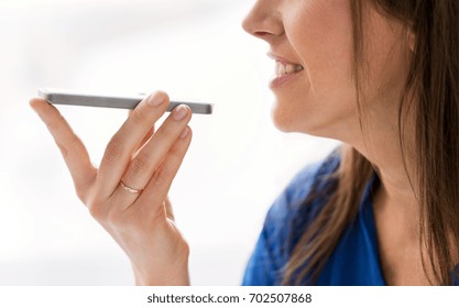 technology, communication and people concept - close up of happy woman using voice command recorder on smartphone - Powered by Shutterstock