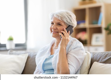 Technology, Communication And People Concept - Happy Senior Woman Calling On Smartphone At Home