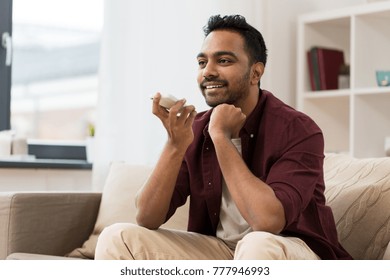 Technology, Communication And People Concept - Happy Smiling Man Using Voice Command Recorder On Smartphone At Home