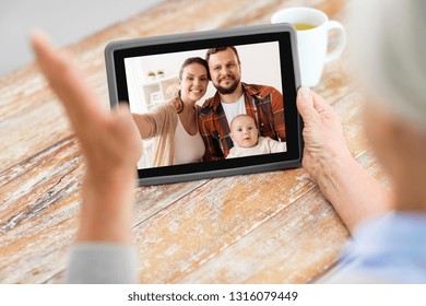 technology, communication and people concept - senior woman having video call with happy family on tablet computer at home - Powered by Shutterstock