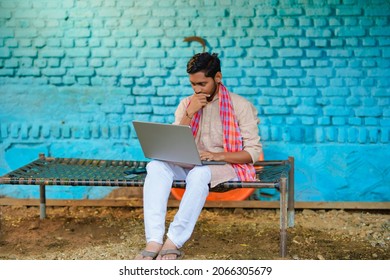 Technology concept : Indian farmer using laptop at home.