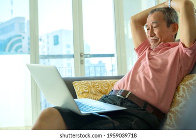 Technology concept, senior citizen using laptop at home. Work from home sitting at the sofa. Worried face thinking about pension
