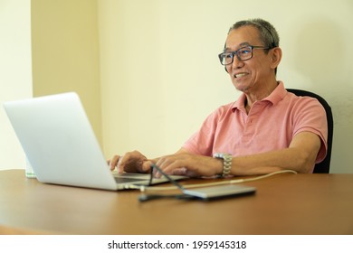 Technology concept, senior citizen using laptop at home. Work from home sitting at the work desk for conference call