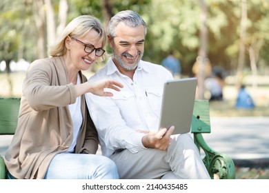 Technology Connect And Modern Elderly Lifestyles Concept. Aged Senior Couple Waving Hands Greeting Grandkids Via Facetime Video Call Internet Conference Outdoors In The Park