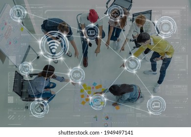 Technology digital virtual screen and Wireless communication connecting over Top view Group Of Asian and diverse Business people brainstorming and helping together in the modern workplace,