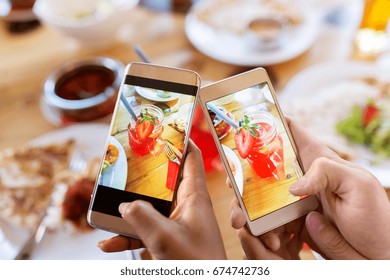 technology, drinks and people concept - hands with smartphone photographing cocktails in mason jar glasses at restaurant - Powered by Shutterstock