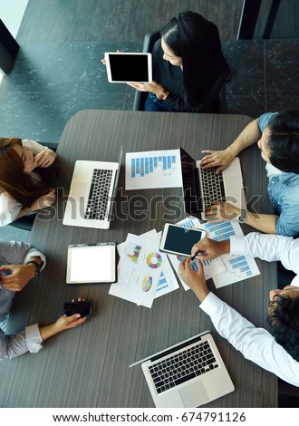 Technology equipment with tablet, laptop, business documents on meeting table