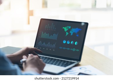 Technology In Finance And Business Marketing Concept. Graphs And Charts Show On Computer's Screen. Modern Businessman Seeing Statistical Data On Laptop In Office
