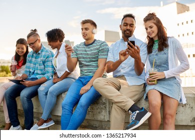 Technologie, Freundschaft und internationales Konzept - Gruppe von Studenten oder Freunden mit Getränken, Smartphones und Tablet-Computer in der Stadt