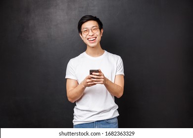 Technology, Gadgets And People Concept. Happy Cheerful Young Man Surprise Girlfriend With Flowers Delivery That He Ordered Using Mobile Phone Application, Laughing Over Funny Meme