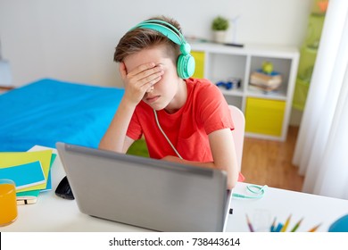 Technology, Gaming, Cyberbullying And People Concept - Upset Boy In Headphones With Laptop Computer At Home Lost Video Game Or Suffer Of Bullying